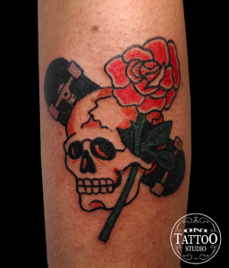 Tatouage d'un crâne old school avec un skate et une rose